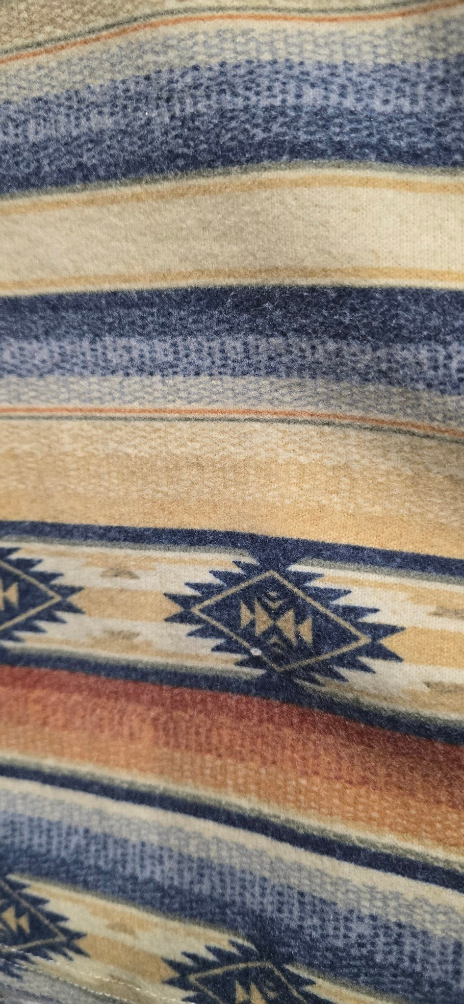 Close-up of the Double D Ranch Cow Camp Henley woven textile with horizontal stripes in cream, navy blue, and rust orange