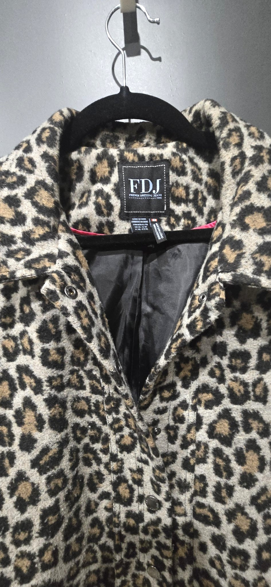 Front view of the FDJ French Dressing leopard fuzzy knit coat with snap buttons on a hanger